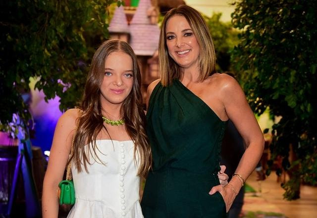 Foto de Ticiane Pinheiro, vestida com vestido verde e sua filha Rafaella Justus, vestida de branco, abraçadas e fazendo pose para foto