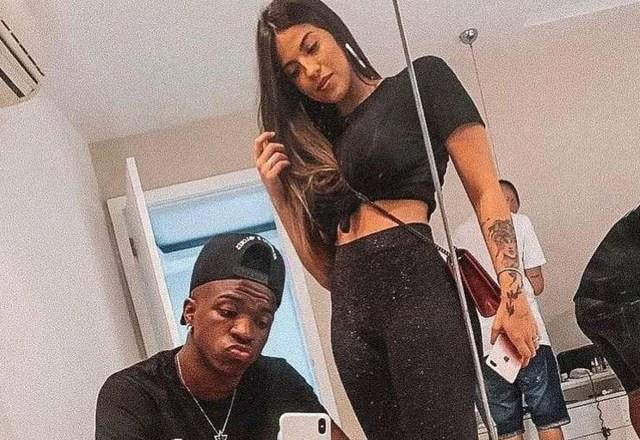 Foto de Manu Mazalli junto com VInicius Junior, posando para foto, com Vinivius Junior com o celular na mão