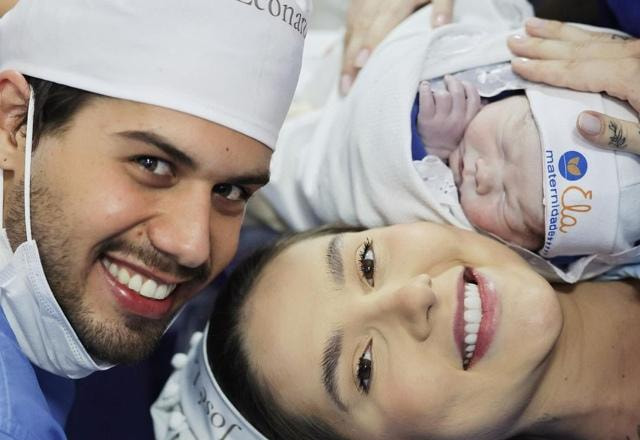 Imagem de Virginia Fonseca no momento do nascimento de seu terceiro filho José Leonardo, na foto com seu esposos Zé Felipe, todos vestidos com roupas hospitalares