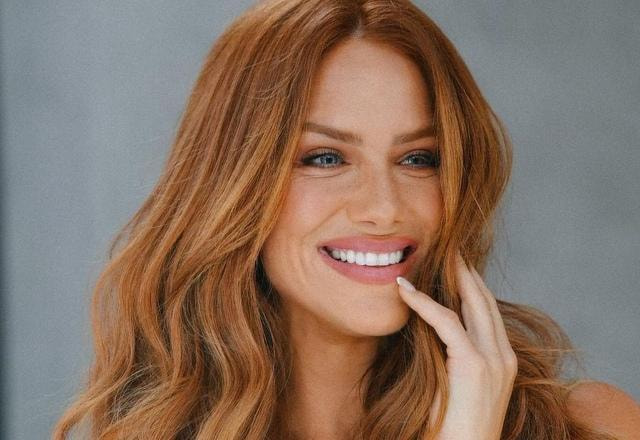 Imagem de Giovanna Ewbank sorrindom com a mão no rosto