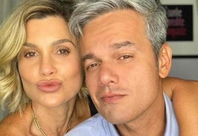 Foto de Flávia Alessandra abraçada com Otaviano Costa, ambos fazendo bico com os lábios