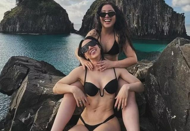 Foto de Mari Fernandez junto com a namorada Julia Ribeiro, as duas de biquini preto em uma praia