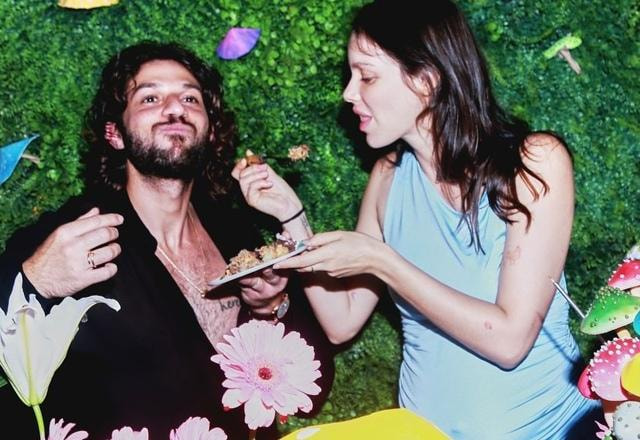 Foto de Laura Neiva ao lado de Chay Suede comendo bolo de aniversário de Laura Neiva