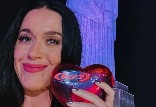 Foto de Katy Perry segurando um coração em frente ao Cristo Redentor