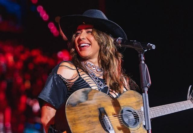 Foto de Lauana Prado em um show, com o violão em mãos