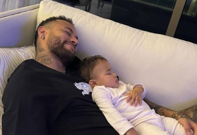 Imagem de Neymar deitado no sofá com sua filha Mavie, deitada em sua barriga