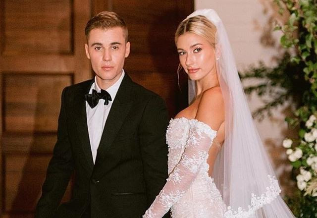 Imagem de Justin Bieber junto com sua esposa Hailey Bieber posando para fotos em sue casamento, vestidos a caráter