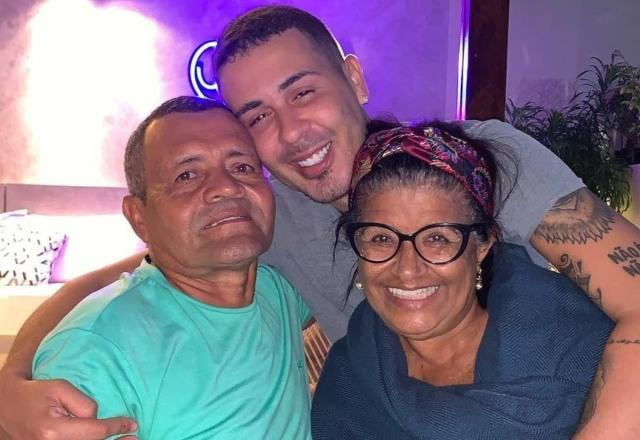 Foto de Carlinhos Maio abraçando sua família, seu pai Virgílio dos Santos e sua mãe