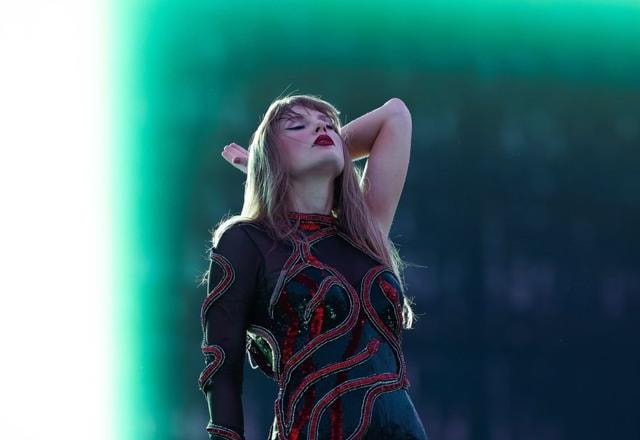 Foto de Taylor Swift em show, com a cabeça para trás e de olhos fechadas