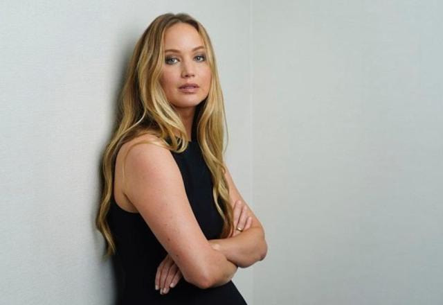 Foto de Jennifer Lawrence encostada em uam parede branca e de vestido preto