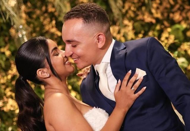Foto de Ary Mirelle e João Gomes em seu casamento, no altar, se beijando, vestidos para o casamento