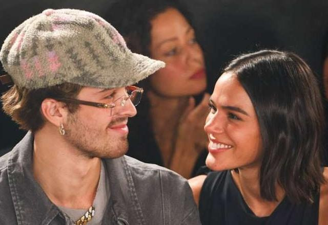 Foto de Bruna Marquezine encarando e sorrindo para João Guilherme, em um desfile