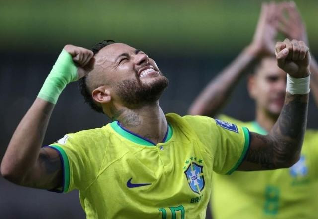 Foto de Neymar vestido com a camisa da seleção brasileira e comemorando