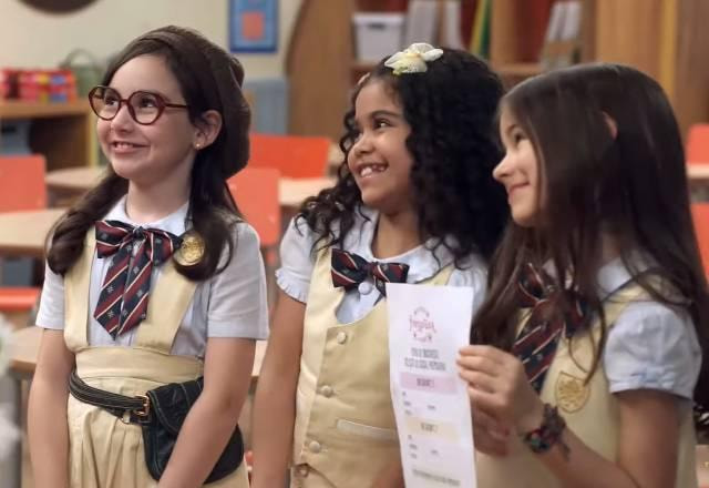 Isadora, Manu e Anna olham sorrindo para os professores