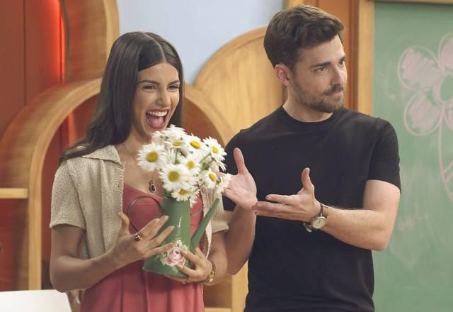 Pilar e Gabriel sorriem e seguram flores