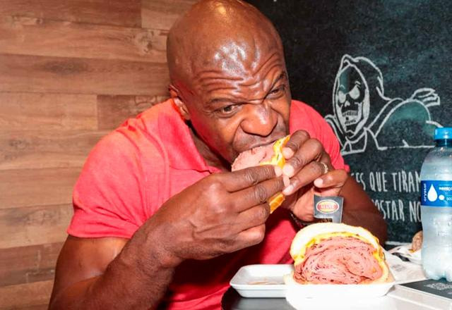 Terry Crews comendo sanduíche no Mercadão de SP.