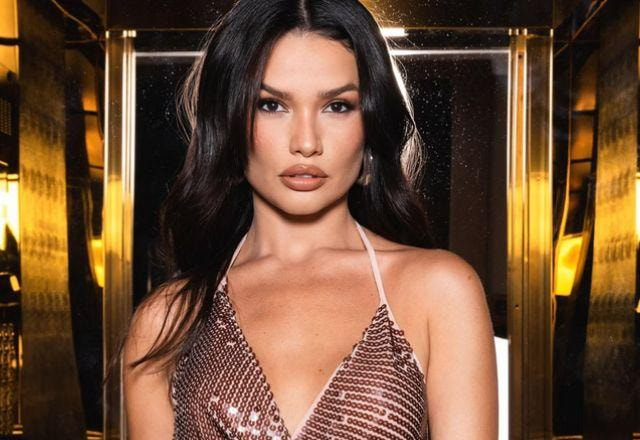 Juliette posa para foto usando vestido brilhoso com uma iluminação mais escura, cabelos soltos