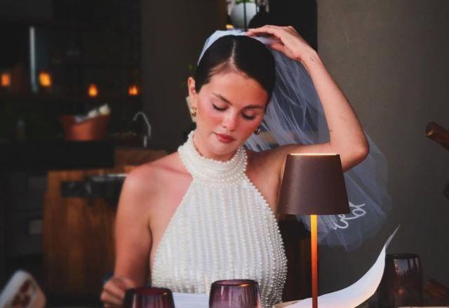 Selena Gomez posa em frente a espelho com vestido branco e véu.