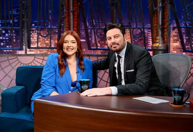 Danilo Gentili posa ao lado de Ariana Nutt no palco do The Noite