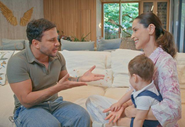 Lucas e Nadja conversam no sofá da casa da apresentadora.