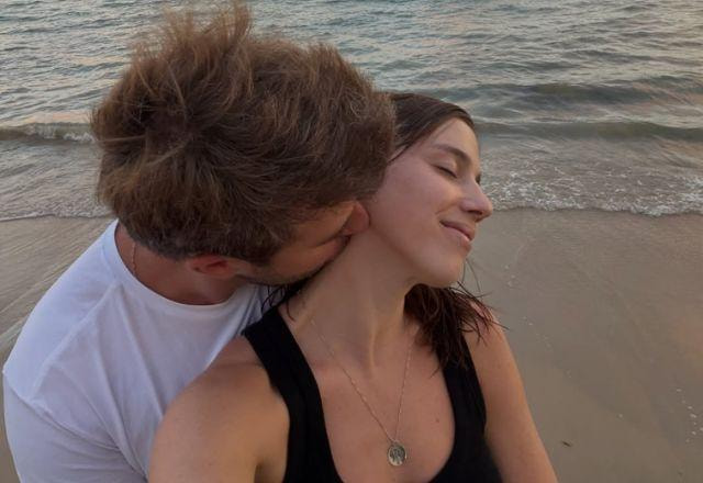 Alice posa na praia com o namorado.