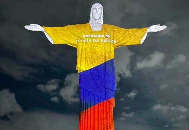 Cristo Redentor iluminado com a bandeira da Colômbia