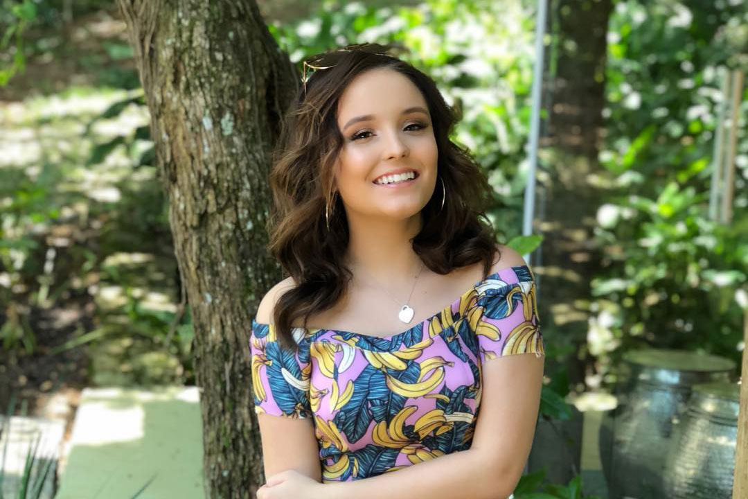 larissa aparece em pé sorrindo