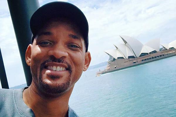 will smith aparece sorrindo de boné com um navio ao fundo
