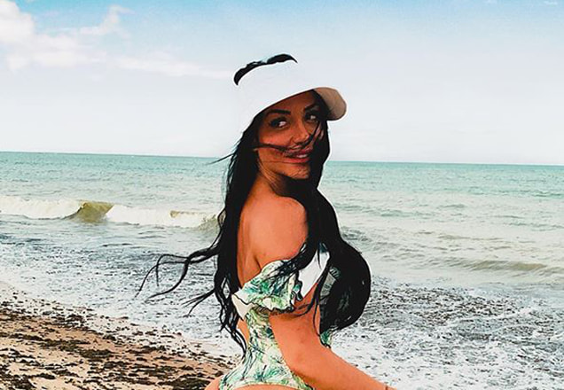 Rhenata Schimidt do Programa do Ratinho posa de maiô em uma praia paradisíaca