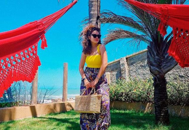De vestido amarelo, Maisa é fotografada entre duas redes vermelhas de praia