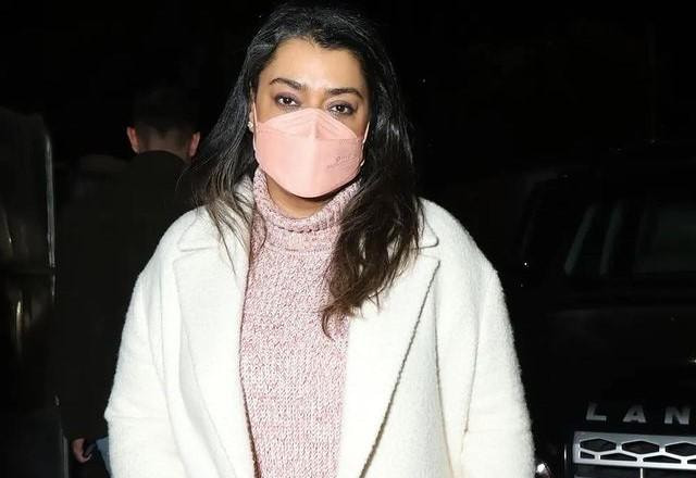 Preta Gil usando casaco branco e máscara de proteção rosa durante show