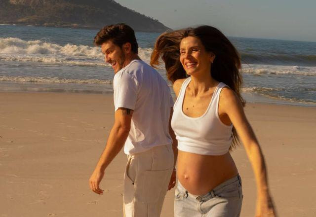 Camila Queiroz e Klebber Toledo posam na praia.