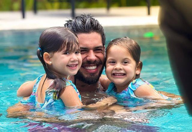 Zé Felipe posa na piscina com as filhas Maria Flor e Maria Alice.