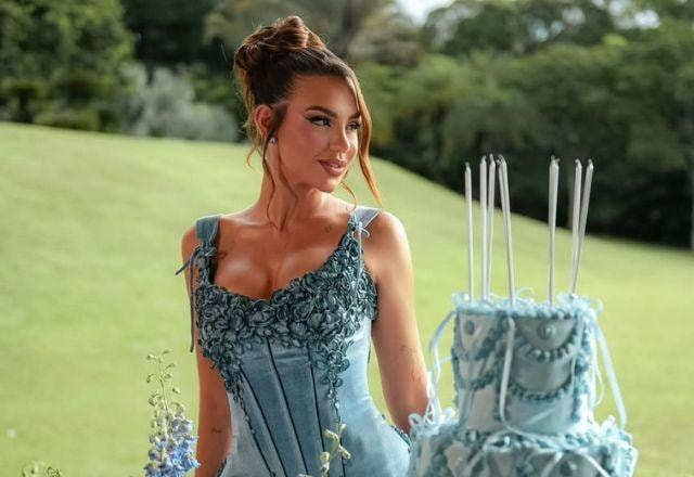 Vivi posa para foto com bolo e vestido azul.